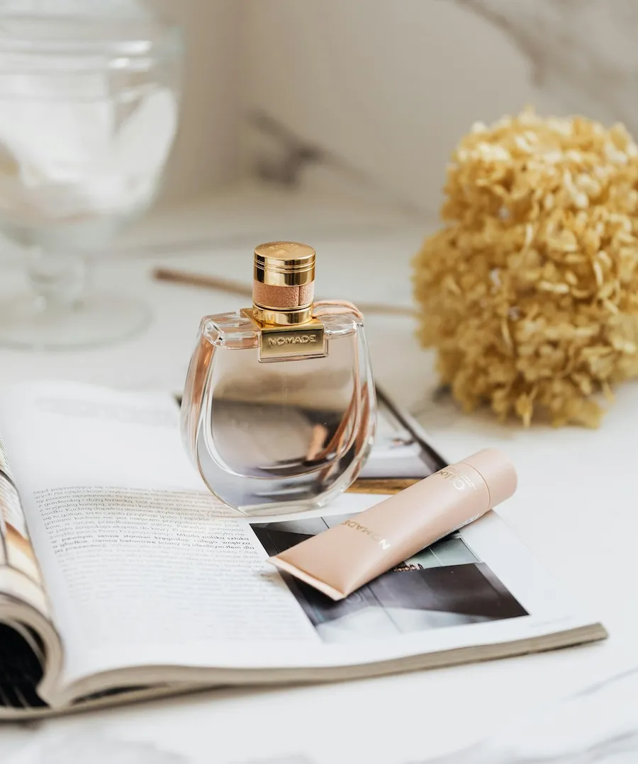 Promotional Tools Cosmetics Marketing PR Stylish perfume, magazine and book on marble table showcase effective marketing materials for cosmetics outreach campaign